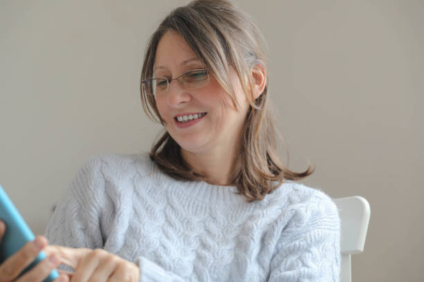 istock Smiling Woman Enjoying Technology Indoors 2191323137