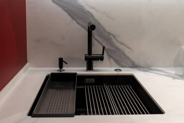 Modern black faucet on kitchen workspace with soap dispenser