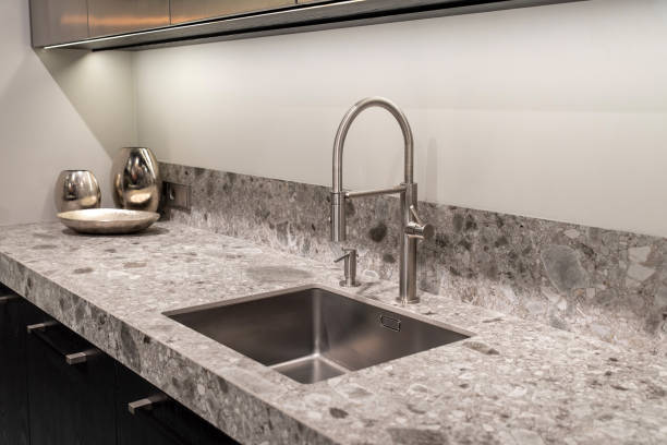istock Stainless steel kitchen faucet with curved design on a marble countertop 2191323355