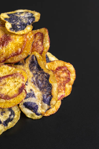 istock Colorful peruvian native potato chips piled up on black background 2191323995
