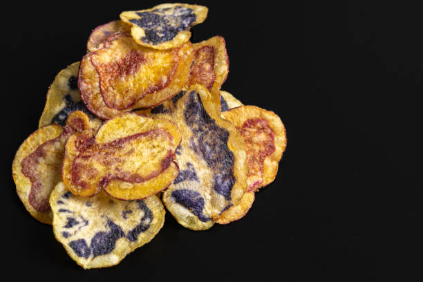 istock Colorful peruvian native potato chips piled on black background 2191324001