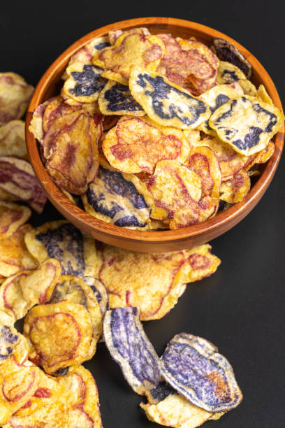 istock Colorful peruvian native potato chips spilling from wooden bowl 2191324017