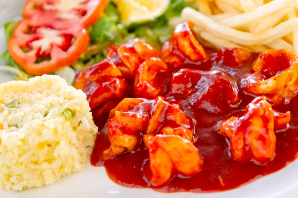 Its spicy flavour is obtained from a sauce made with various dried chillies, which are usually served with white rice, fresh salad or frijoles de la olla (beans from the pot) and corn tortillas.