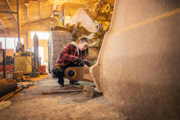 istock Woman in Overalls Fixing Heavy Equipment 2191327117