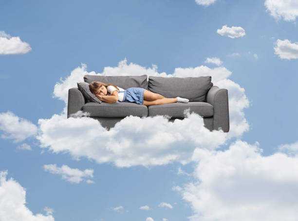 istock Little girl sleeping on a sofa above clouds 2191328046