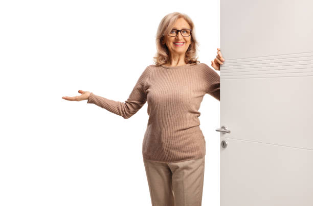 istock Woman opening a door and gesturing welcome 2191328106