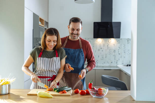 istock Couple cooking together in a modern kitchen preparing fresh vegetables 2191332001