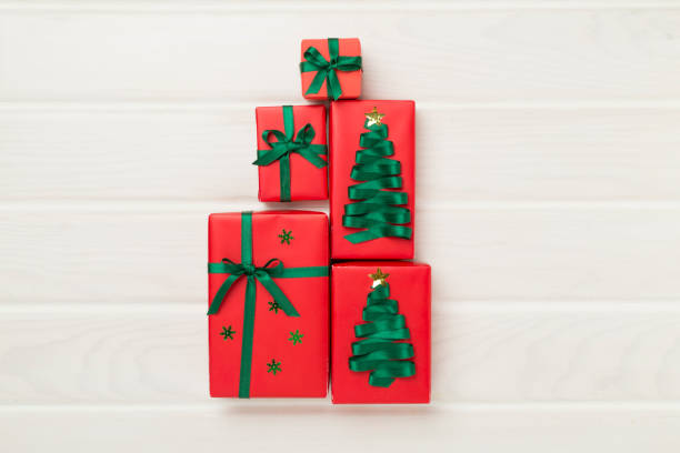 istock Gift boxes in Christmas tree shape on wooden background, top view 2191334634