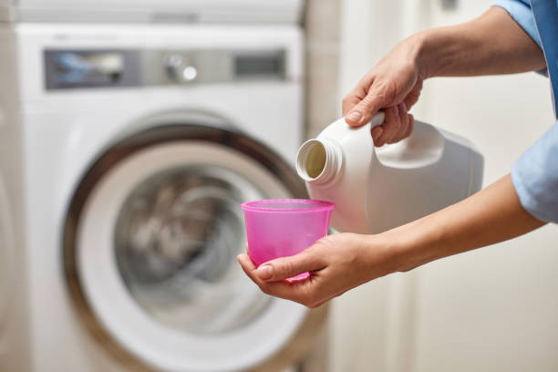 istock Woman pours liquid laundry detergent into plastic cap 2191341736