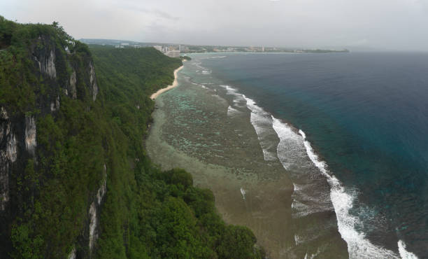 Tumon bay and Guam sea coast aerial panoramic view with surf waves on reef