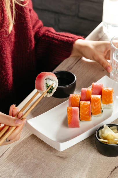 istock sushi roll with tuna, red fish in hand at the restaurant 2191347480