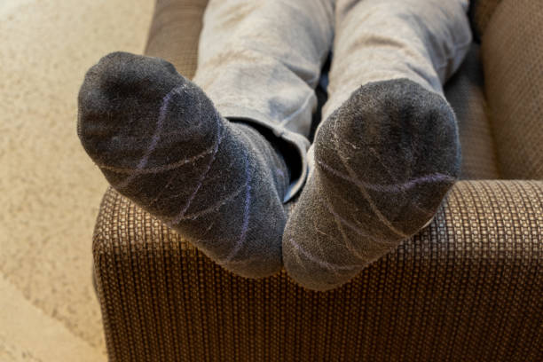 istock Man lying on sofa with feet up on armrest 2191351720