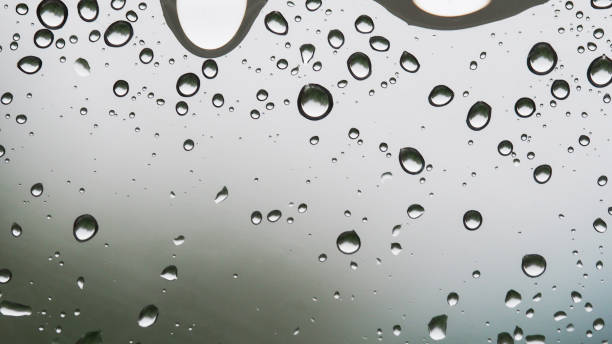 Raindrops on Glass with Blurred Background. Suitable for weather, nature, and abstract-themed stock photo collections.