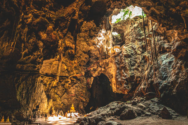 A stunning view of a Buddha statue inside Tham Luang Cave, Petchaburi, Thailand. The sacred figure is illuminated by natural light filtering through the cave’s openings, creating an awe-inspiring and serene atmosphere. This historic and spiritual site is a testament to Thailand’s cultural and natural wonders, making it a truly amazing place to visit.