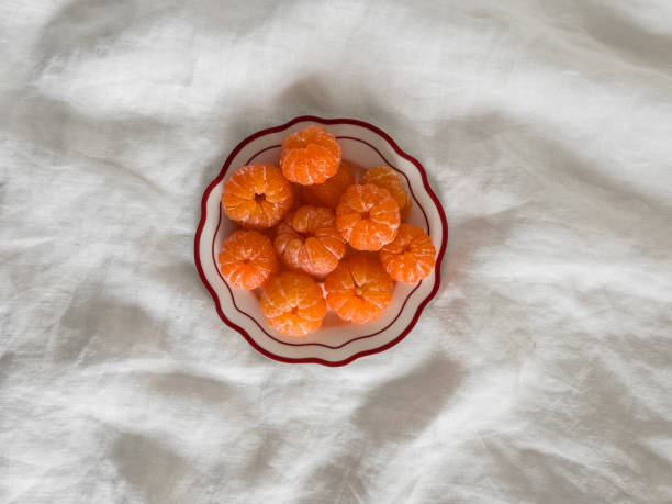 istock Peeled tangerines on a plate on a light background, top view 2191352366