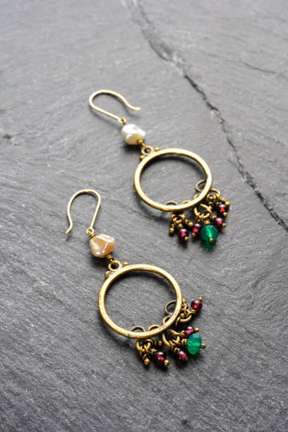 istock Brass earrings with small gemstones on a black slate 2191353572