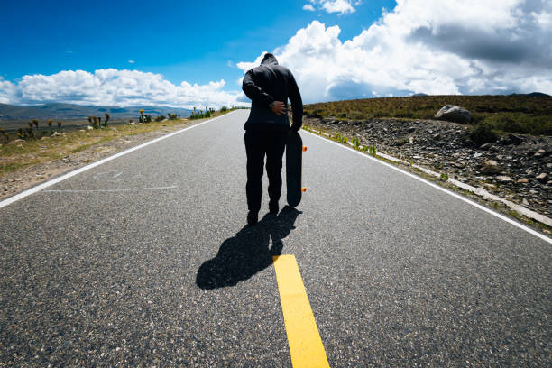 istock Skateboarder with back pain while skateboarding on the mountain road 2191357853