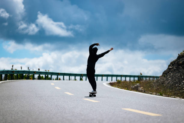 istock Skateboarder with back pain while skateboarding on the mountain road 2191357973
