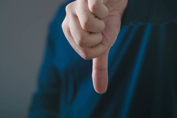 istock A close-up of a hand showing a thumbs down gesture, symbolizing disapproval or negative feedback in a modern setting. 2191358031