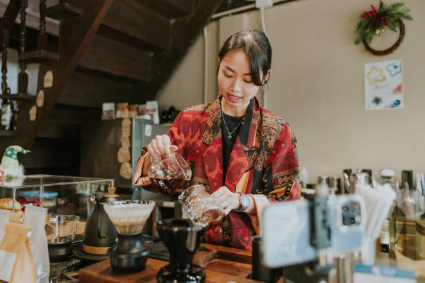 istock Pouring hot cafe Americano, cool down technic, Artisan barista woman is live streaming while teaching how to do hot espresso technic in her cafe. 2191359372