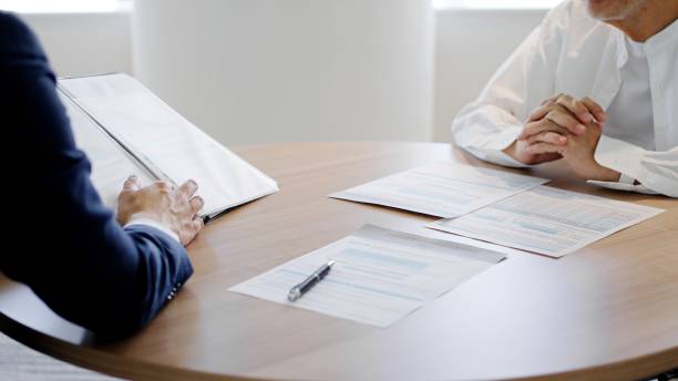 Elderly people receiving sales from businessmen stock photo