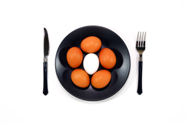 istock Brown egg on black plate with cutlery set together on white background closeup view Flatlay food concept photography, White background 2191364860
