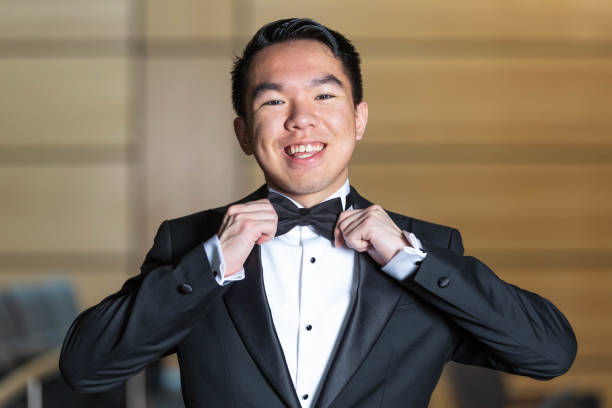istock A young man wearing a tuxedo is adjusting his bow tie carefully 2191368215