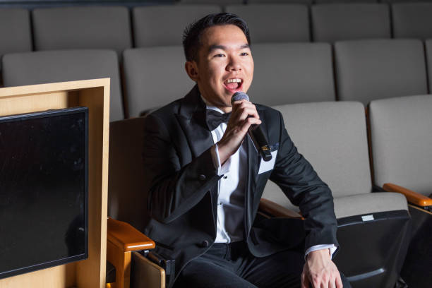 istock A man in a tuxedo sits in an auditorium with a microphone 2191368335