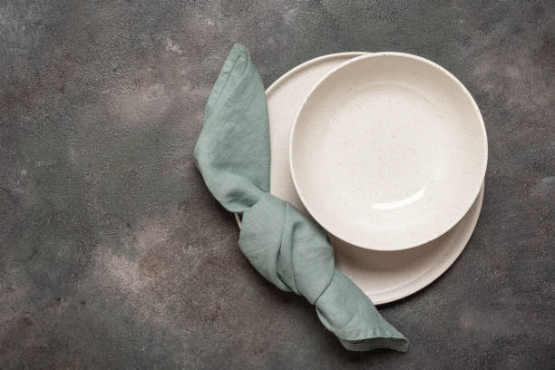 istock Set of two empty plates and linen napkin on dark rustic background, top view, flat lay, copy space 2191369182
