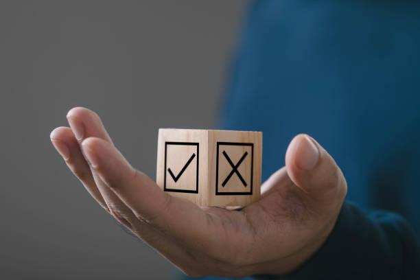 istock A hand holding wooden blocks with check and cross marks, representing decision making and choices in a modern setting. 2191370858