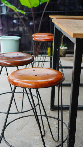 istock Wood and metal bar stools without backrest on gray concrete floor 2191370947