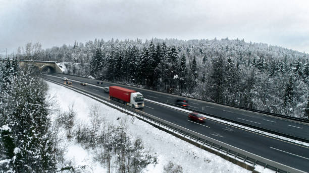 istock Snowy Highway with Traffic Through a Winter Forest 2191371817