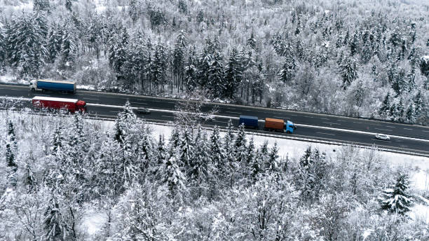 istock Snowy Highway with Trucks and Vehicles in Motion 2191371989