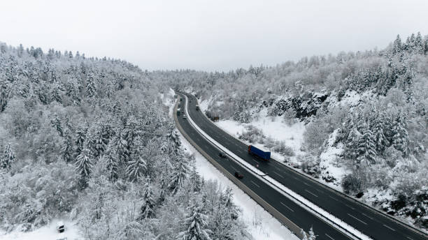 istock Winter Highway Winding Through Snowy Forest 2191372136