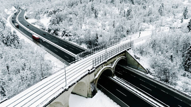 istock Aerial View of Snowy Highway Intersection with Bridge 2191372164