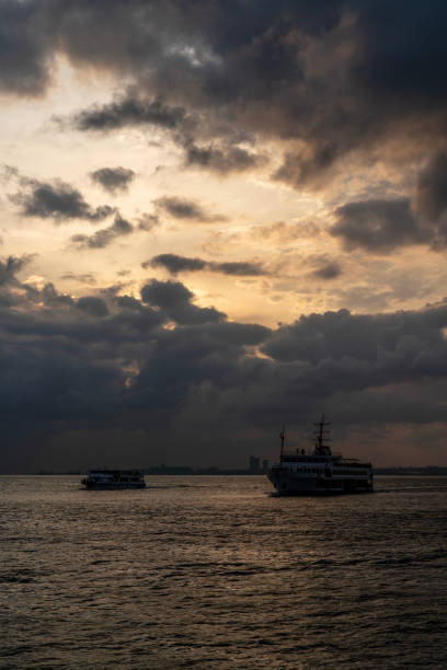 A serene yet dramatic scene on the Bosphorus, with two vessels sailing under a textured sky at twilight. This image evokes the unique beauty of Istanbul's waterways. Photographed with a Sony camera.
