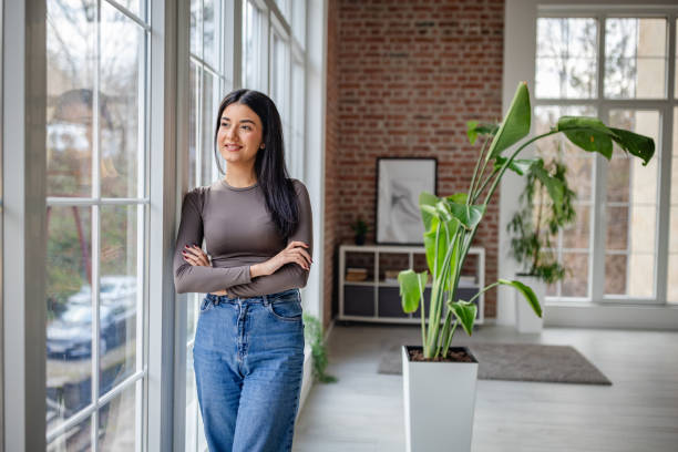 istock Confident woman standing by modern spacious window 2191373635