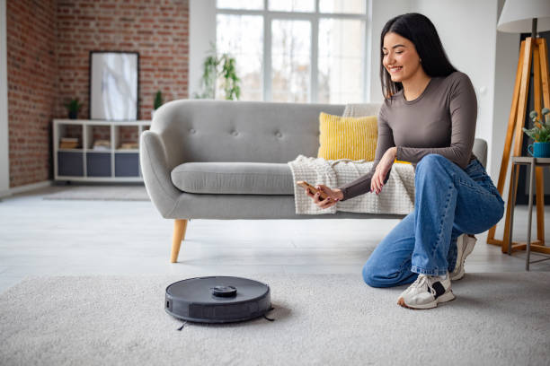 istock Woman controls robot vacuum in stylish apartment 2191373752