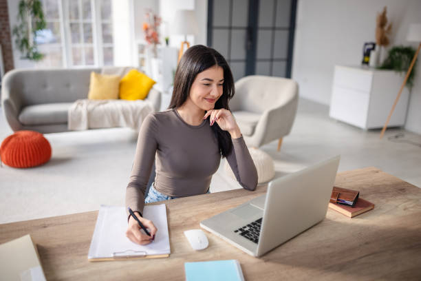 istock Woman working remotely at desk facing a laptop screen 2191374336
