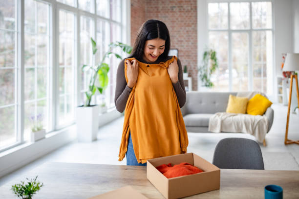 Woman lovingly examines her clothing from a package