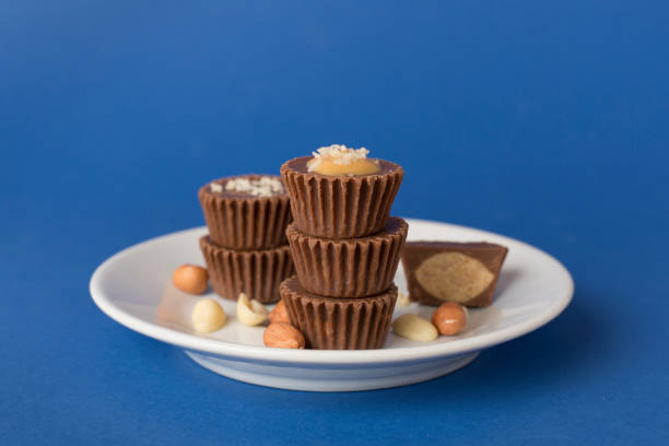 Tasty chocolate peanut butter cups on color background