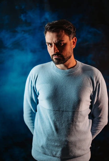istock Serious Mid-Adult Man Standing Against A Blue Background 2191376239