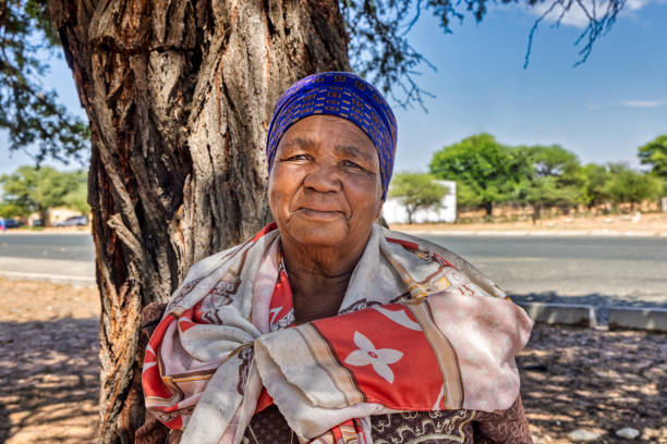 villaggio, ritratto di single donna anziana sorridente africana. all'ombra di un albero vicino alla strada - tswana people foto e immagini stock