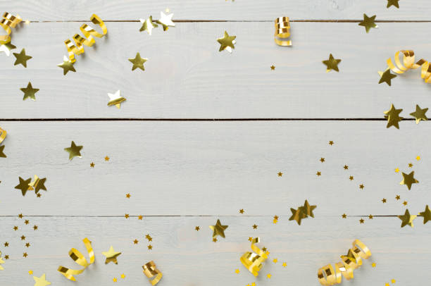 istock Golden confetti on wooden background, top view 2191376325