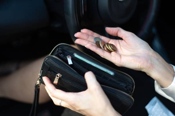 istock Person holding coins and wallet in car. 2191377605