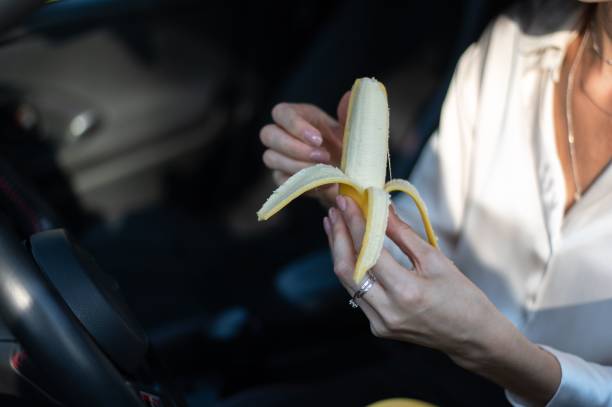 istock Man holding a peeled banana in a car 2191377608