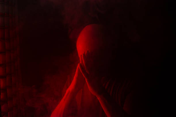 istock Bald and bearded man making despair gesture with hand. Isolated on smoky black background with colored lights. 2191378742