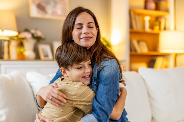 istock Loving Mother Embracing Her Young Son on a Comfortable Home Couch 2191381144