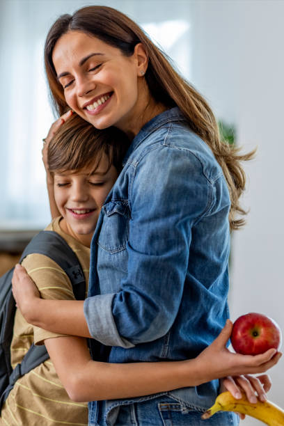 istock Mother Embracing Her Son Before School While Holding Healthy Snacks 2191381327