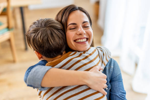 Happy Mother Hugging Her Child in a Bright Home Environment stock photo